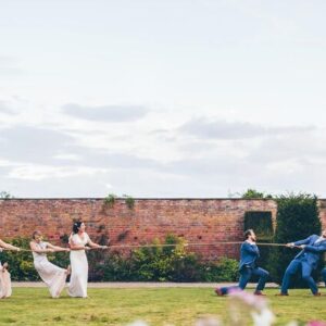 21c2b6abc9a342bead205195433da1be-760x428-Optimized-bridesmaids-ushers-tug-of-war-combermere-abbey.jpeg